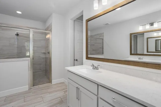 a bathroom with a shower sink and mirror