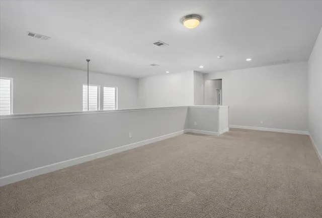 an empty room with chandelier and windows