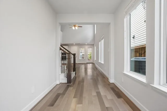 a view of a hallway with wooden floor and staircase