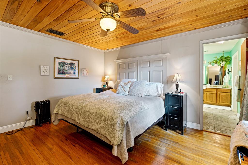 9504 Fort King Road Dade City, FL 33525 - Photo 16 of 51 a spacious bedroom with a bed and a chandelier