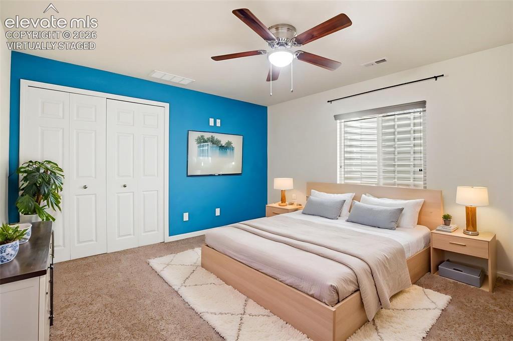 7806 Dutch Loop Colorado Springs, CO 80925 - Photo 22 of 41 a bedroom with a large bed and a chandelier
