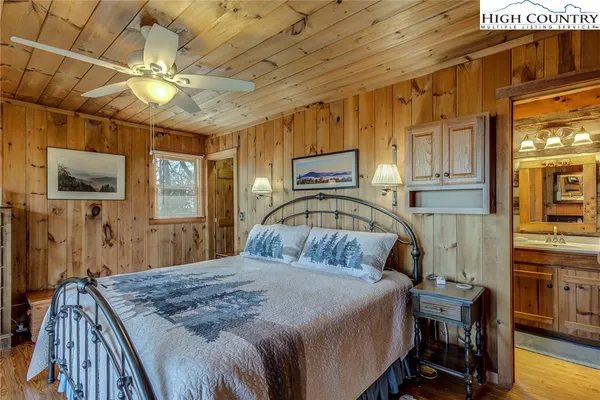 a bedroom with a bed a chandelier and flat screen tv