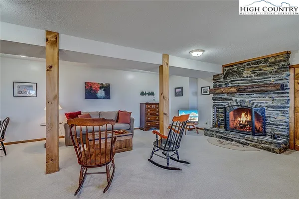 a living room with furniture a fireplace and kitchen view