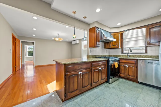a large kitchen with stainless steel appliances granite countertop a sink and cabinets