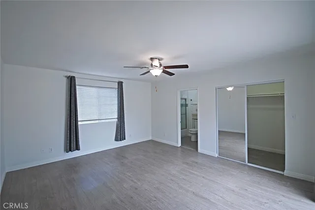 a view of an empty room with a chandelier fan