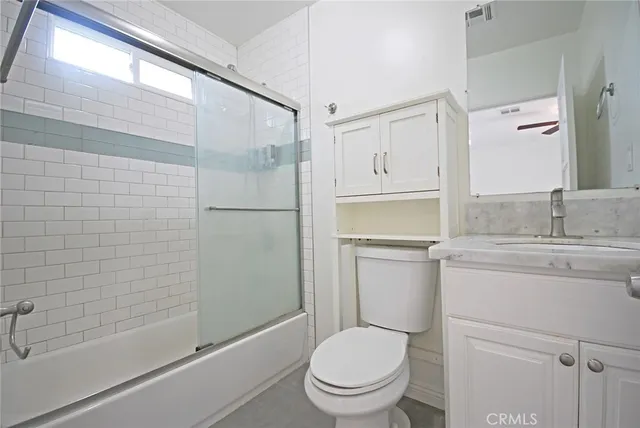 an empty room with wooden floor chandelier fan and windows