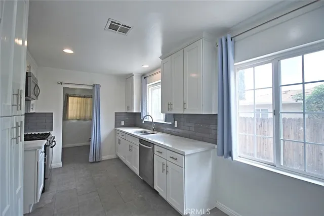 a kitchen with sink stove and cabinets