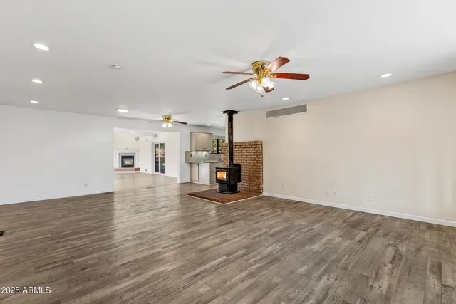 an empty room with windows and ceiling fan