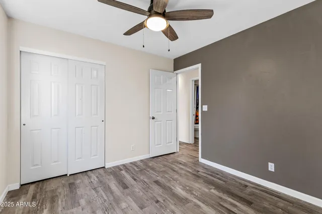 an empty room with a window and a ceiling fan