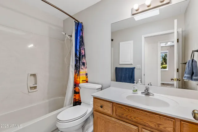 wooden floor in an empty room with a chandelier fan