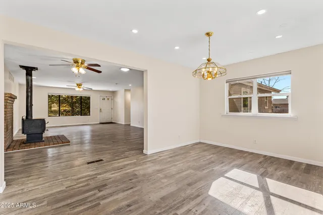 a view of an empty room with a window and fire place