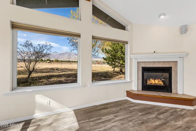 a view of a livingroom with wooden floor and a fireplace