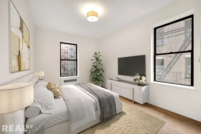 a bedroom with a bed and a flat screen tv