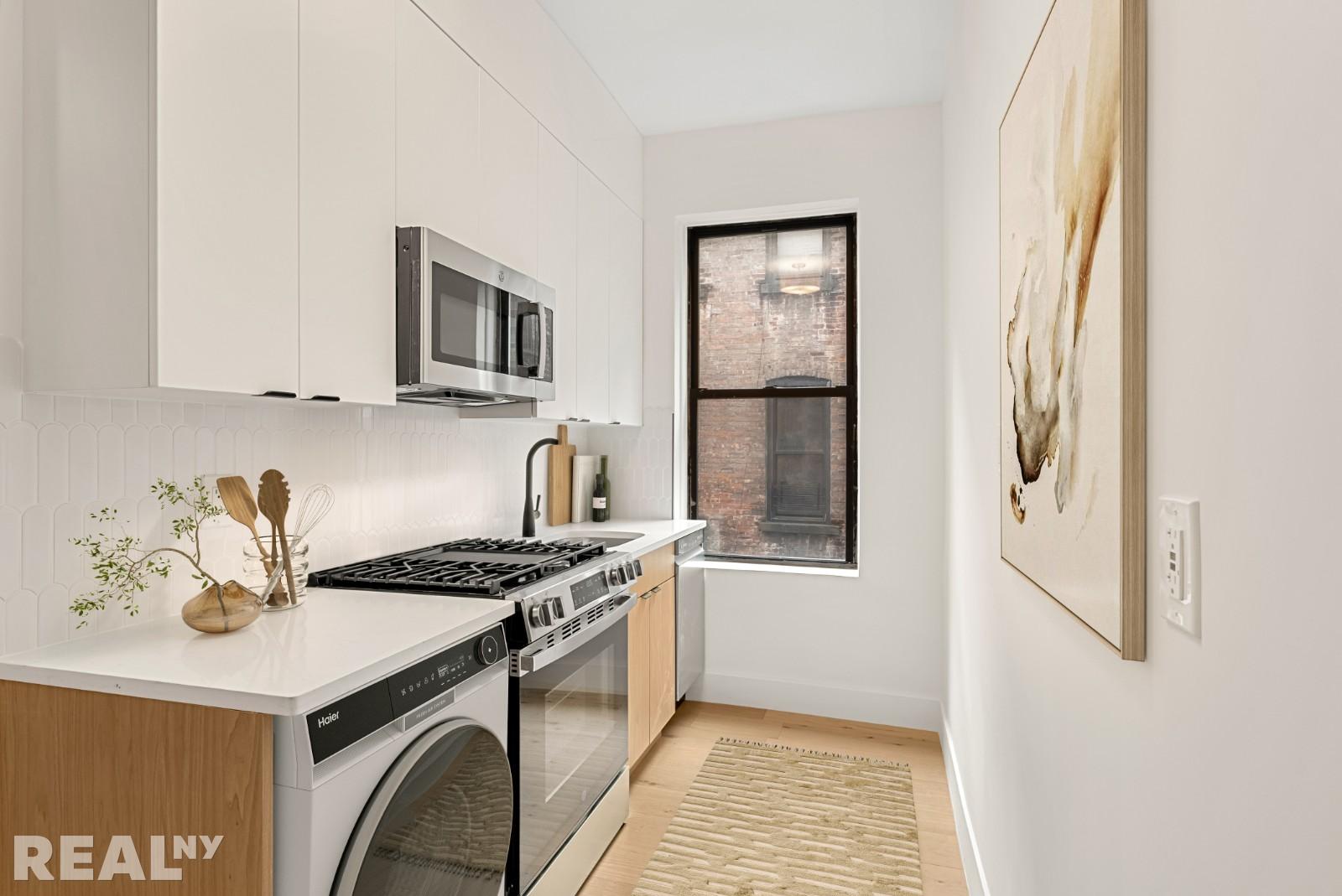 668 Riverside Drive, Unit 4G Manhattan, NY 11360 - Photo 5 of 11 a kitchen with stainless steel appliances granite countertop a stove and a refrigerator