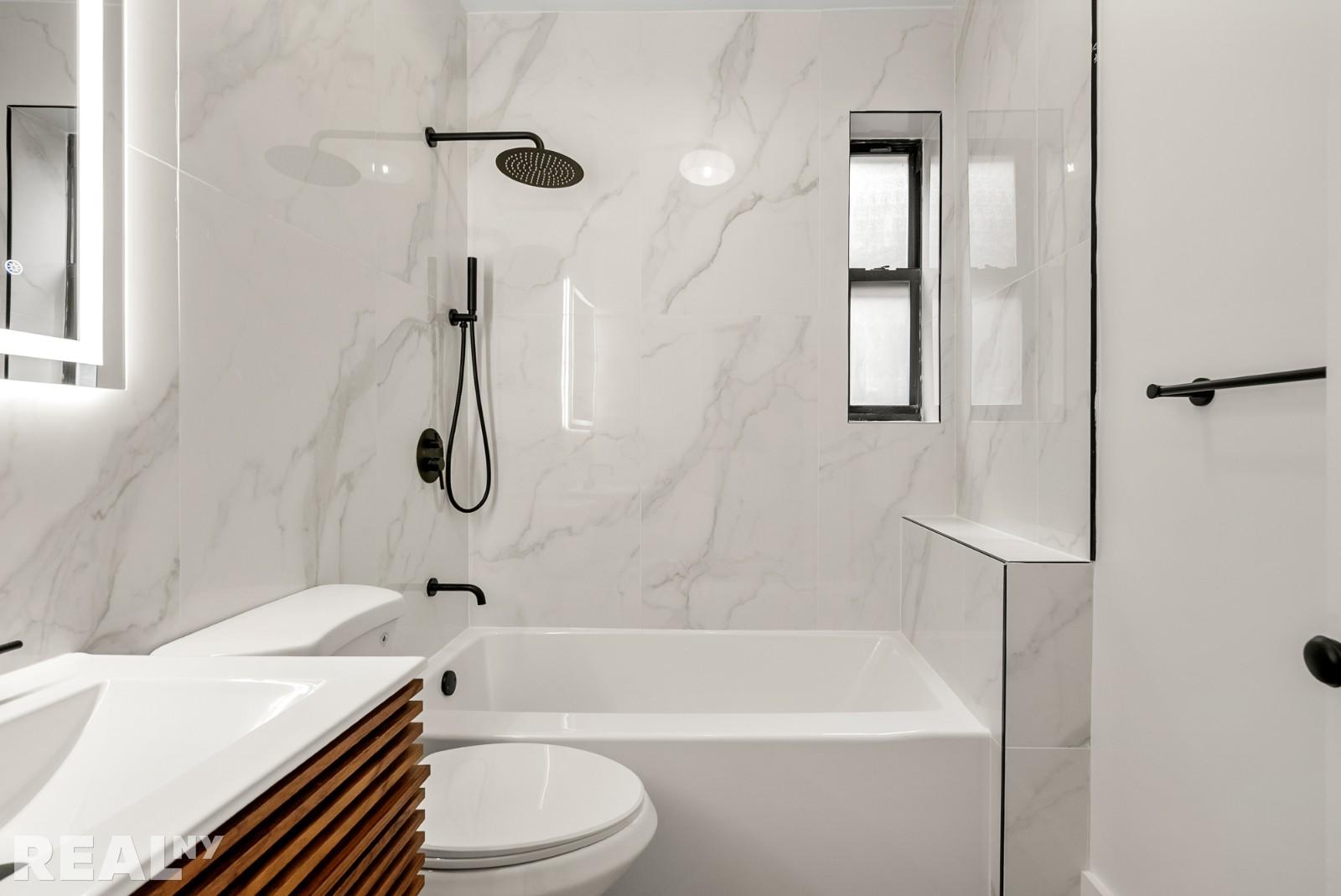 668 Riverside Drive, Unit 4G Manhattan, NY 11360 - Photo 7 of 11 a bathroom with a sink a toilet and a bathtub