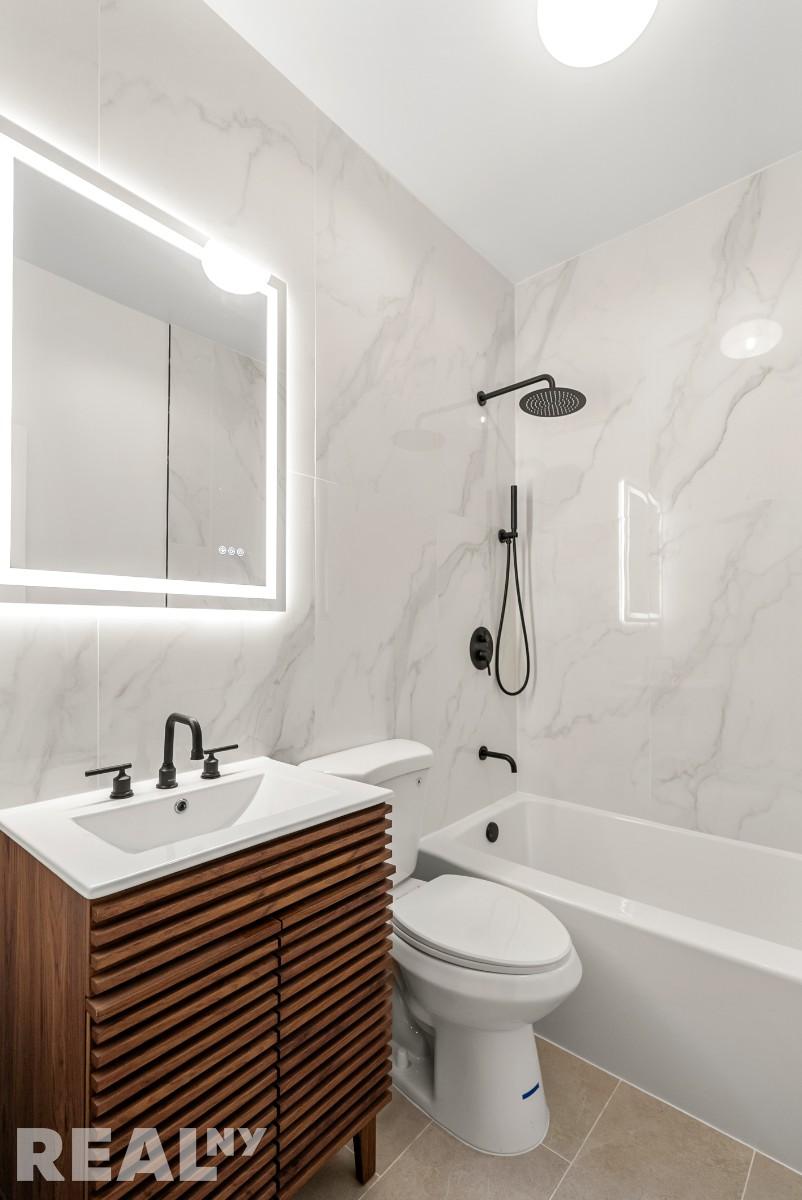 668 Riverside Drive, Unit 4G Manhattan, NY 11360 - Photo 8 of 11 a bathroom with a sink a toilet and shower