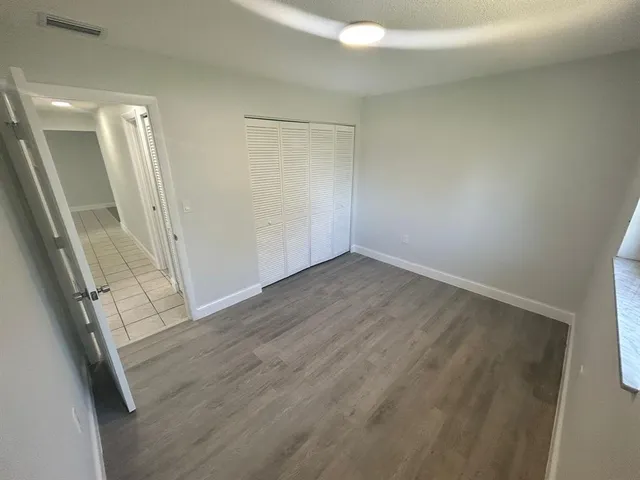 an empty room with wooden floor and door