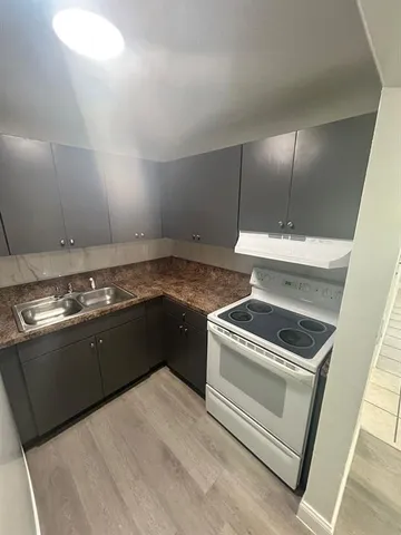 a kitchen with granite countertop a stove and a sink