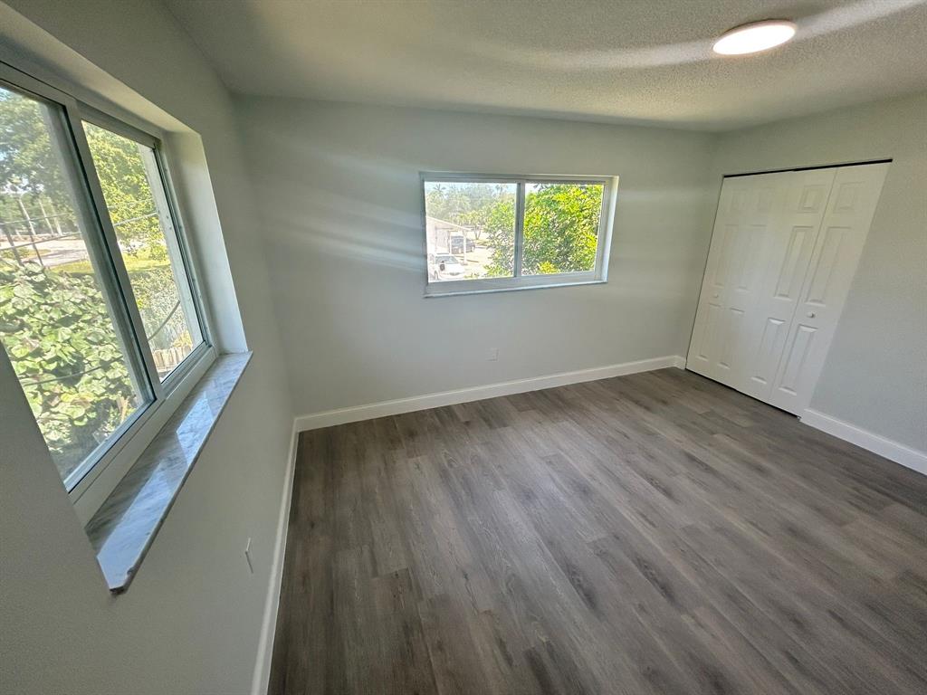 6601 Southwest 46th Street, Unit 203 Davie, FL 33314 - Photo 10 of 14 a view of an empty room with wooden floor and a window