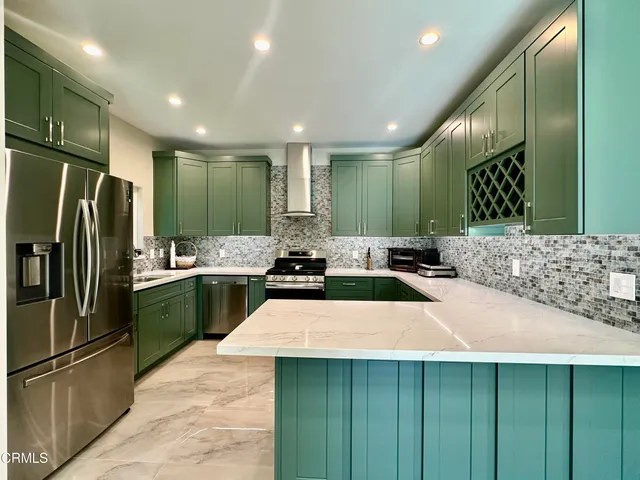 a kitchen with stainless steel appliances a sink a counter top cabinets