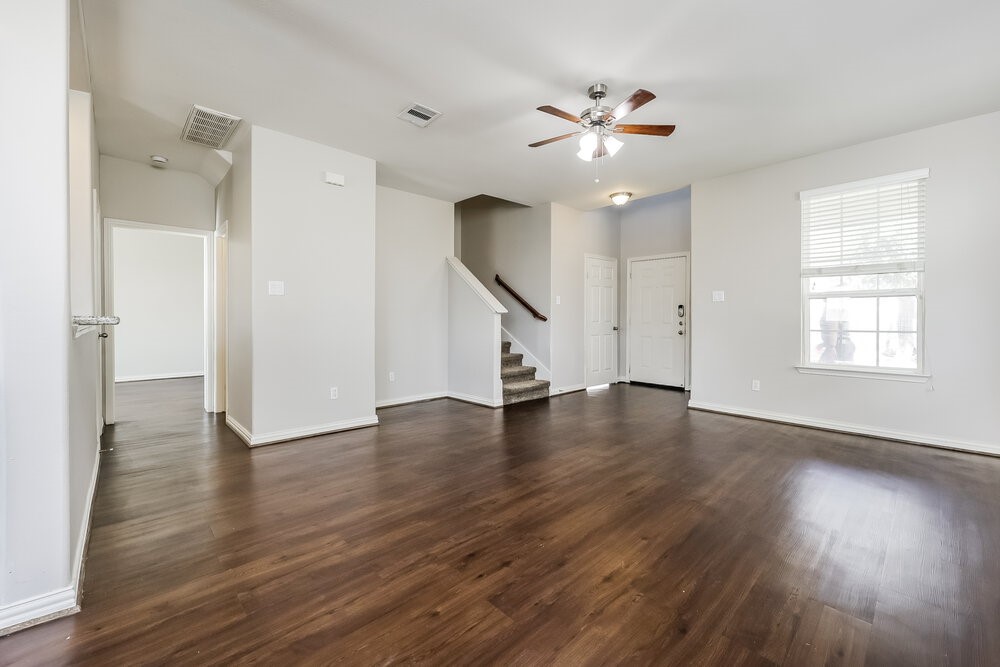 2818 Mesquite Ridge Drive Houston, TX 77073 - Photo 5 of 17 a view of an empty room with wooden floor and a ceiling fan