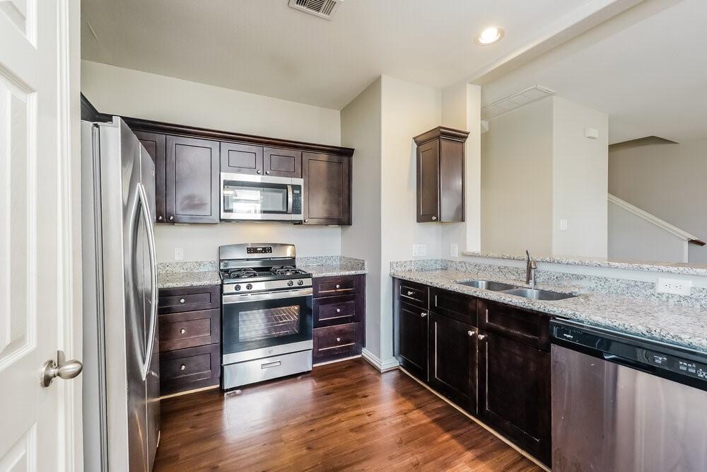 2818 Mesquite Ridge Drive Houston, TX 77073 - Photo 8 of 17 a kitchen with stainless steel appliances granite countertop a sink stove and refrigerator