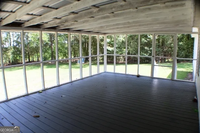 a view of empty room with wooden floor and floor to ceiling windows