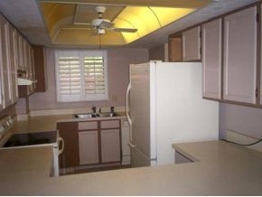 990 8th Street South, Unit 1 Naples, FL 34102 - Photo 4 of 10 a kitchen with stainless steel appliances a refrigerator a sink a stove and white cabinets