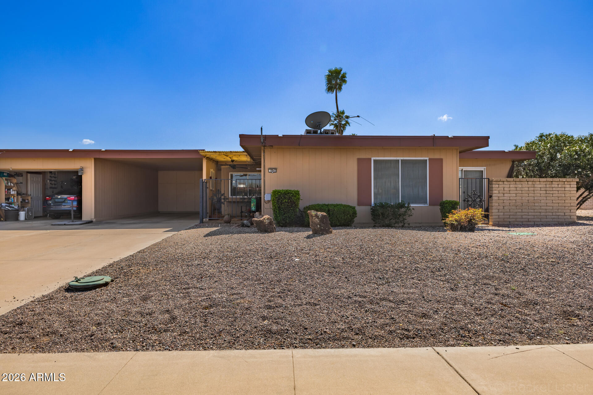 9845 West Royal Ridge Drive Sun City, AZ 85351 - Photo 1 of 28 a view of a house with a backyard and a garage