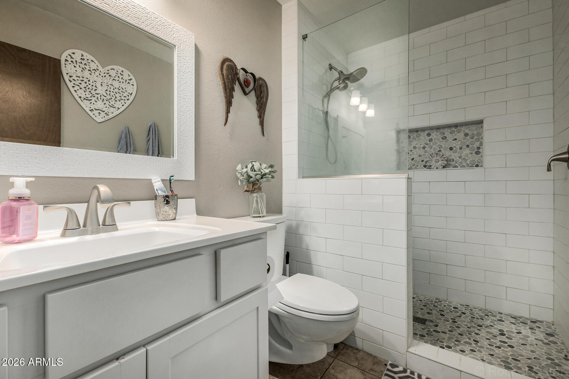 9845 West Royal Ridge Drive Sun City, AZ 85351 - Photo 25 of 28 a bathroom with a toilet sink and mirror