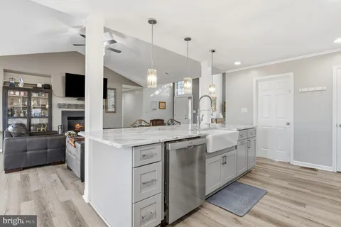 a kitchen with stainless steel appliances a dining table chairs a sink and a refrigerator