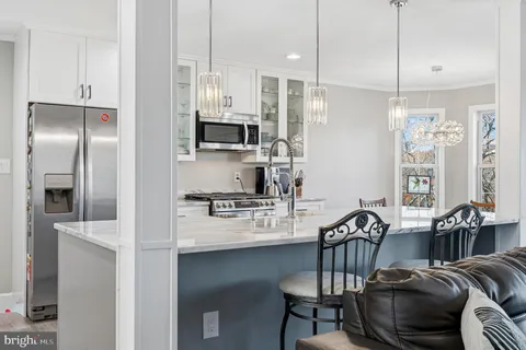 a kitchen with stainless steel appliances kitchen island granite countertop a refrigerator and a stove top oven