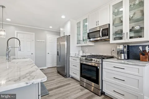 a bathroom with a granite countertop sink a large mirror and a refrigerator