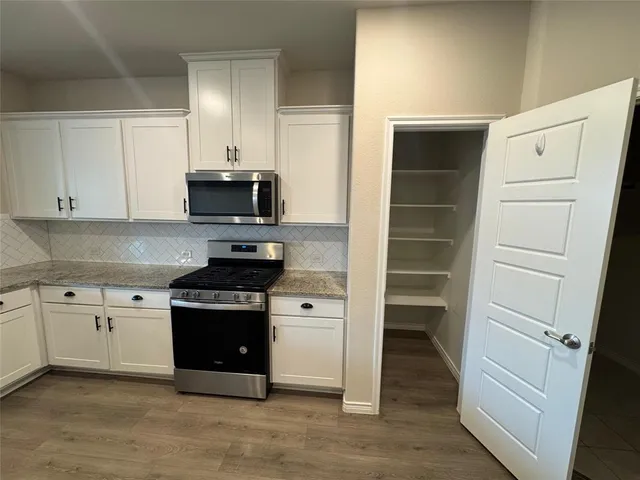 a kitchen with a stove and a refrigerator
