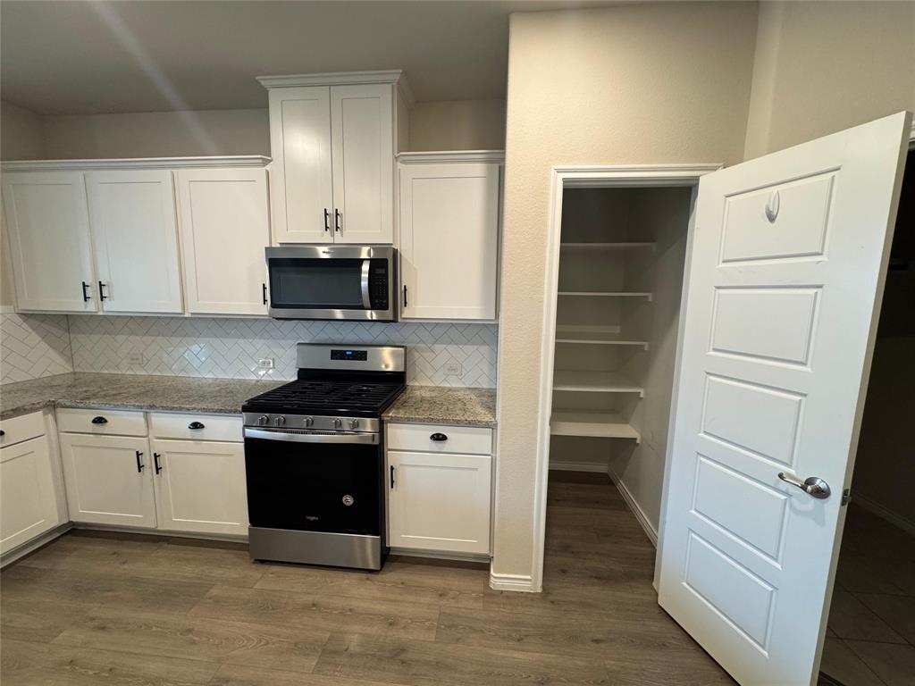 940 Azure Lane Celina, TX 75009 - Photo 16 of 26 a kitchen with a stove and a refrigerator