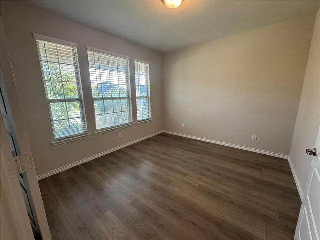 an empty room with windows and fan