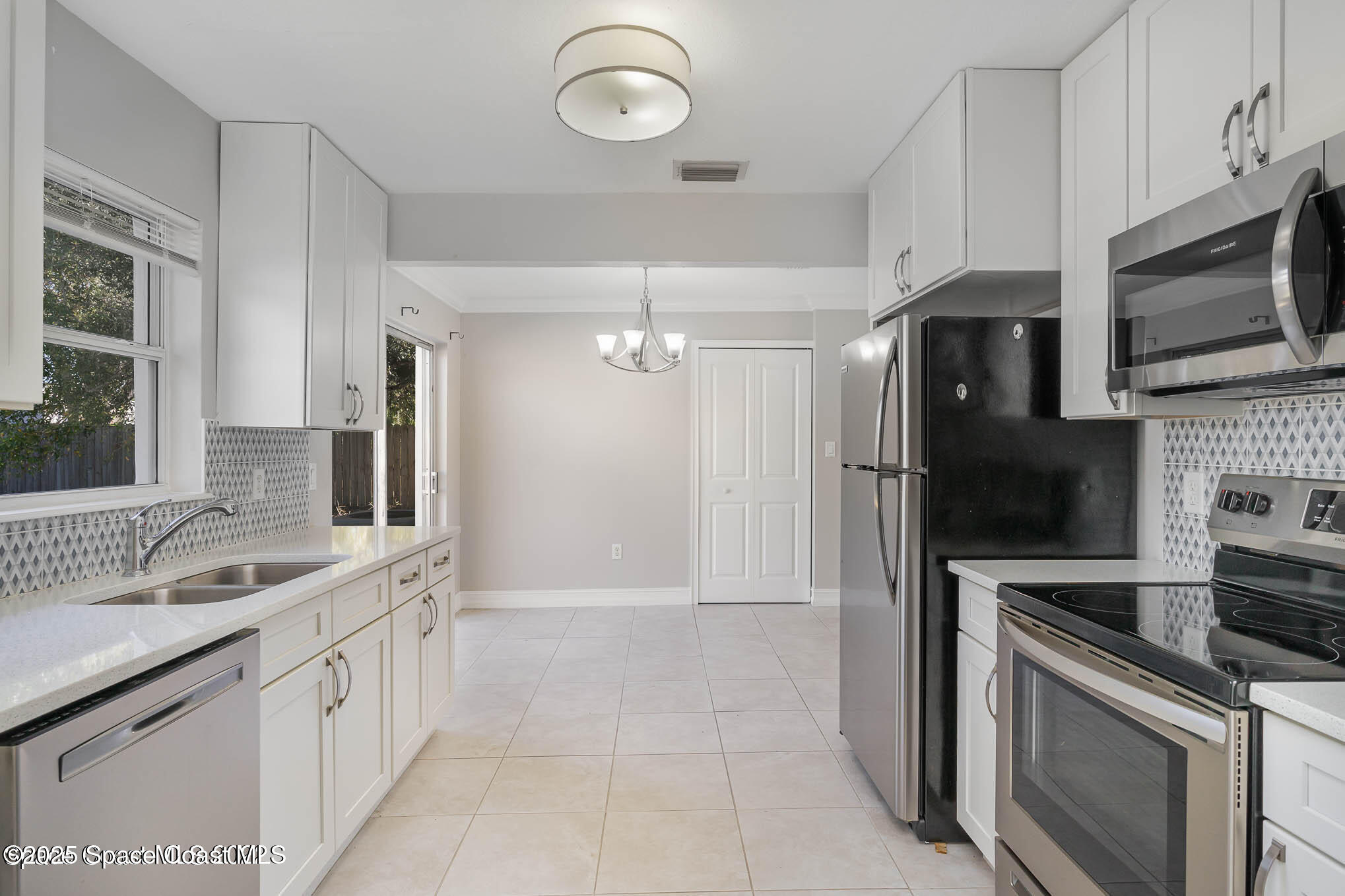 2360 Apache Drive Melbourne, FL 32935 - Photo 4 of 13 a kitchen with a sink stainless steel appliances and cabinets