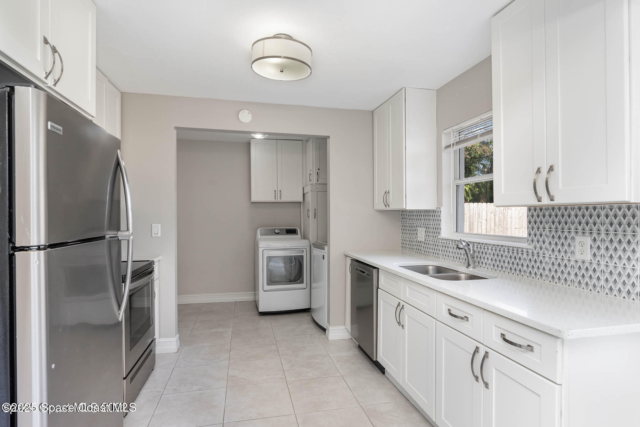 2360 Apache Drive Melbourne, FL 32935 - Photo 5 of 13 a kitchen with white cabinets and refrigerator