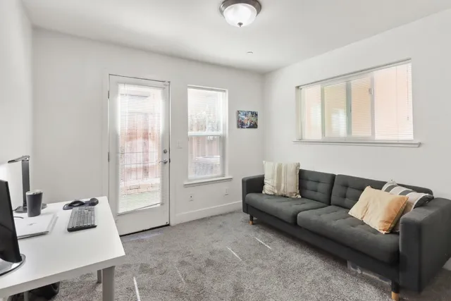 a view of a patio with table and chairs potted plants and floor to ceiling window