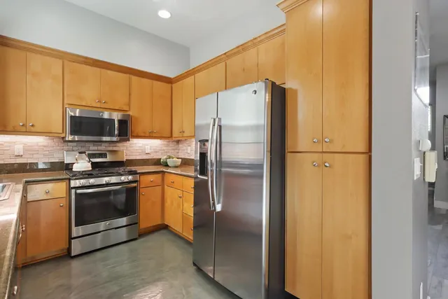 a kitchen with granite countertop a sink a stove and cabinets