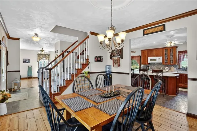 a view of a dining room and livingroom with furniture wooden floor a chandelier
