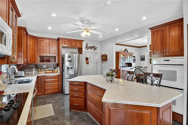 a kitchen with stainless steel appliances granite countertop a sink dishwasher stove and refrigerator