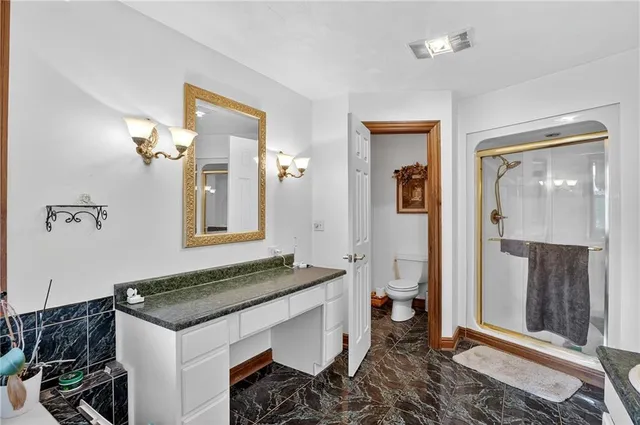 a spacious bathroom with a granite countertop sink and a mirror