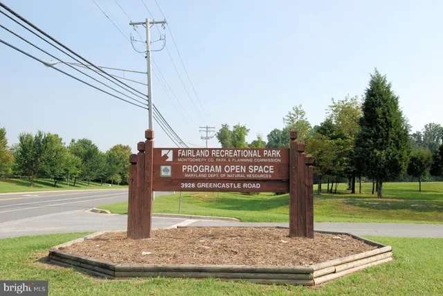 a view of a house with a big yard and large trees