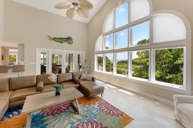 a dining hall with stainless steel appliances kitchen island granite countertop a living room view and furniture