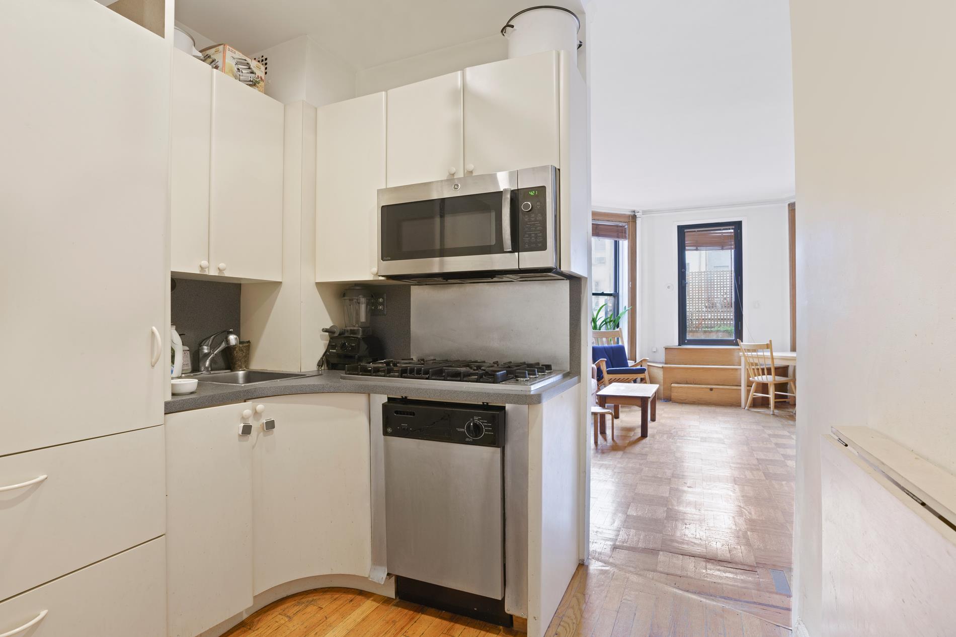 142 East 37th Street, Unit 23 Manhattan, NY 10016 - Photo 13 of 15 a kitchen with stainless steel appliances a stove a sink and white cabinets