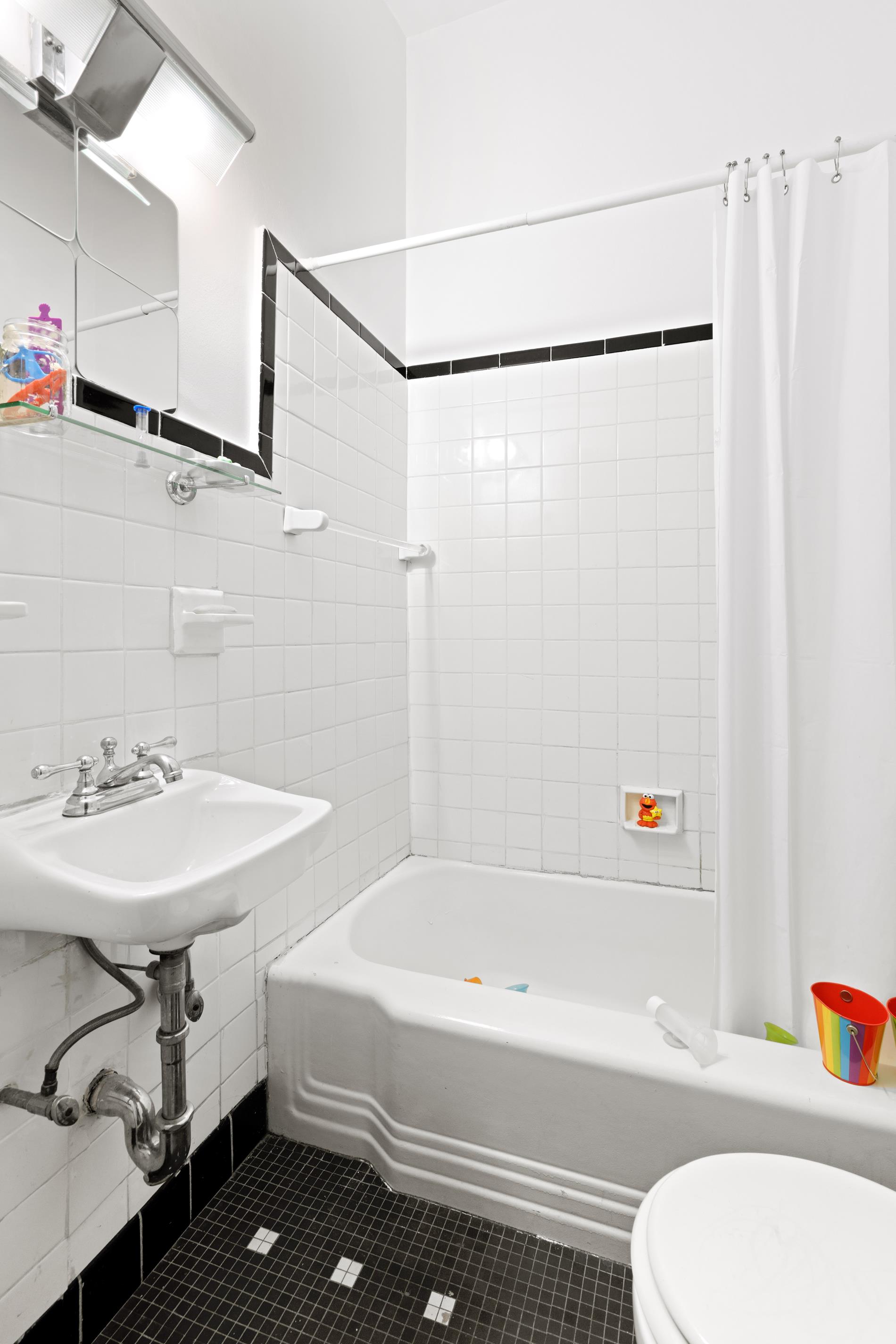 142 East 37th Street, Unit 23 Manhattan, NY 10016 - Photo 15 of 15 a bathroom with a sink and a bathtub