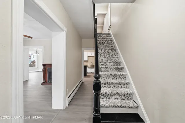 a view of empty room with wooden floor fan and window
