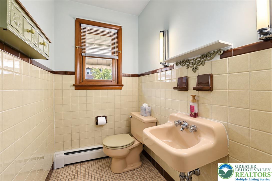 1539 Spring Garden Street Wilson, PA 18042 - Photo 17 of 34 Vintage tile walls and a wood-framed window define this classic half bathroom.