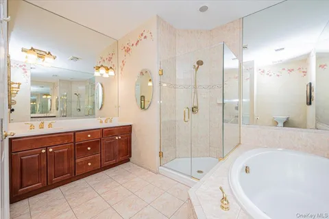 a bathroom with a tub a sink shower and mirror